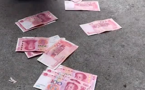 男子当街抛撒万余元现金